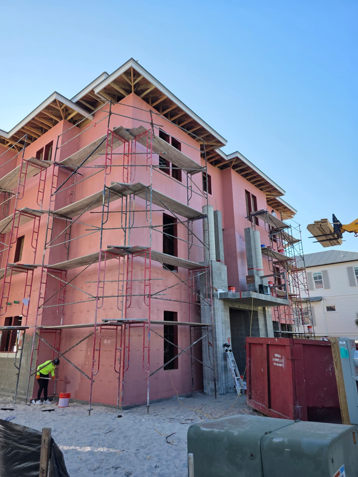 Multi-story beachfront stucco with scaffolding